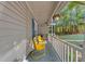 Cozy front porch featuring bright yellow chairs, hanging flower baskets, and serene outdoor view at 117 Candace Pl, Cary, NC 27513