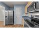 A view of the kitchen with stainless steel refrigerator and black microwave over the stove at 117 Candace Pl, Cary, NC 27513