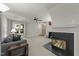 Bright and open living room with fireplace, large window, and comfortable gray sofa at 117 Candace Pl, Cary, NC 27513