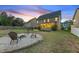 Large, fenced backyard with a patio, screened porch, firepit, and lush landscaping at 117 Woodlark Ln, Holly Springs, NC 27540