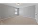 Neutral bedroom with carpeted floors, window for natural light, and a closet for storage at 117 Woodlark Ln, Holly Springs, NC 27540
