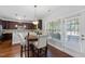 Bright dining area featuring wooden floors, modern lighting, and a door leading to the outdoors at 117 Woodlark Ln, Holly Springs, NC 27540