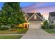 Charming home featuring a manicured lawn, two car garage, and stone and gray shingle exterior at 117 Woodlark Ln, Holly Springs, NC 27540