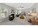 Bright living room features plush seating, a modern fireplace, and natural light from large windows at 117 Woodlark Ln, Holly Springs, NC 27540