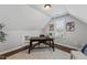 Attic office with wood floors, desk, and window at 117 Woodlark Ln, Holly Springs, NC 27540