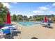 Community pool with lounge chairs and tables, perfect for summer fun at 117 Woodlark Ln, Holly Springs, NC 27540
