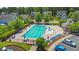 Aerial view of community pool surrounded by lush landscaping, seating, and a gated fence at 117 Woodlark Ln, Holly Springs, NC 27540