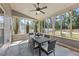 Relaxing screened porch with an outdoor dining area, ceiling fan, and a view of the backyard at 117 Woodlark Ln, Holly Springs, NC 27540
