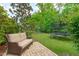 Landscaped backyard with comfortable wicker furniture and a trampoline, perfect for outdoor enjoyment at 1401 Everette Fields Rd, Morrisville, NC 27560