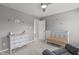Neutral Bedroom features a crib, gray walls, white distressed dresser, and ceiling fan at 1401 Everette Fields Rd, Morrisville, NC 27560