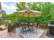Outdoor deck featuring a dining set with umbrella, lush green trees in backyard at 1401 Everette Fields Rd, Morrisville, NC 27560