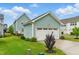 Charming home exterior featuring a detached garage with landscaping, a manicured lawn, and a sunny sky at 1448 Big Falls Dr, Wendell, NC 27591