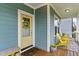 Inviting front porch featuring a cheerful yellow door and comfortable seating area at 1448 Big Falls Dr, Wendell, NC 27591