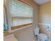 Bright bathroom featuring a toilet, window with blinds, and neutral wall color at 1509 Logan St, Durham, NC 27704