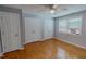 Bedroom with hardwood floors, ceiling fan, window, and ample closet space at 1509 Logan St, Durham, NC 27704