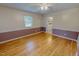 A bedroom with hardwood floors, wainscotting, a ceiling fan and a view of the adjoining bathroom at 1509 Logan St, Durham, NC 27704