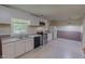 Well-lit kitchen with white cabinets, stainless steel appliances, and tiled backsplash at 1509 Logan St, Durham, NC 27704