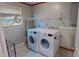 Well-equipped laundry room with washer, dryer, shelving, and a window for natural light at 1509 Logan St, Durham, NC 27704