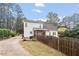 Fenced backyard showcasing a two-story home with a deck, screened porch, and mature trees at 151 Donnibrook, Fuquay Varina, NC 27526