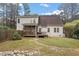 Fenced backyard featuring a two-story home with a screened porch and deck, set amidst lush greenery at 151 Donnibrook, Fuquay Varina, NC 27526