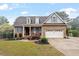 Charming brick home featuring dormer windows, shutters, attached garage with basketball hoop, and lush landscaping at 151 Donnibrook, Fuquay Varina, NC 27526