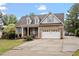 Charming brick home featuring dormer windows, shutters, attached garage with basketball hoop, and well-maintained landscaping at 151 Donnibrook, Fuquay Varina, NC 27526