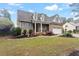 Charming brick home featuring dormer windows, shutters, attached garage with basketball hoop, and manicured front yard at 151 Donnibrook, Fuquay Varina, NC 27526