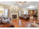 Spacious living room with hardwood floors, a fireplace, and comfortable seating with views into the dining and kitchen area at 151 Donnibrook, Fuquay Varina, NC 27526
