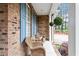 Inviting front porch with rocking chairs, brick columns, hanging plants, and lush front yard at 151 Donnibrook, Fuquay Varina, NC 27526