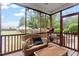 Inviting screened porch featuring wicker furniture, offering a relaxing view of the backyard and storage shed at 151 Donnibrook, Fuquay Varina, NC 27526