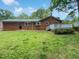 Red brick home featuring a spacious backyard and wooden deck, perfect for outdoor entertaining at 1522 Goodwin Rd, Durham, NC 27712