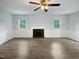 Bright living room with fireplace, ceiling fan, and natural light from the windows at 1522 Goodwin Rd, Durham, NC 27712
