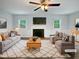 Bright, staged living room with fireplace, ceiling fan, and natural light from the windows at 1522 Goodwin Rd, Durham, NC 27712