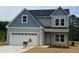 Charming two-story home with blue and gray siding, a two-car garage, and freshly laid straw at 160 Tupelo Dr, Spring Hope, NC 27882