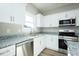Modern kitchen with white cabinets, granite countertops, and stainless steel appliances at 160 Tupelo Dr, Spring Hope, NC 27882