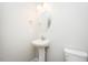 Neat powder room featuring an oval mirror, pedestal sink and white toilet at 160 Tupelo Dr, Spring Hope, NC 27882