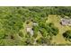 Aerial view of wooded property and several outbuildings surrounded by lush trees at 1661 Reno Sharps Store Rd, Bear Creek, NC 27207