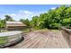 A wooden deck overlooking a serene, green landscape and a rustic wooden building at 1661 Reno Sharps Store Rd, Bear Creek, NC 27207