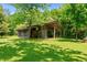 Rustic barn is situated in a lush green pasture with mature trees providing shade, offering country charm at 1661 Reno Sharps Store Rd, Bear Creek, NC 27207