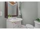 A well-lit bathroom featuring a vanity, large mirror, and a toilet, offering a fresh and clean space at 1661 Reno Sharps Store Rd, Bear Creek, NC 27207