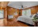 Bright bedroom featuring wood paneling, hardwood floors, ceiling fan, and bright window at 1661 Reno Sharps Store Rd, Bear Creek, NC 27207