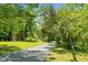 Gravel driveway leading through lush green landscape, creating an inviting entrance to the property at 1661 Reno Sharps Store Rd, Bear Creek, NC 27207