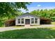 Exterior view of the outbuilding with rustic wood and gray siding, featuring large windows and a gravel lot at 1661 Reno Sharps Store Rd, Bear Creek, NC 27207
