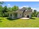 View of the home's back exterior with a wood deck and a lush green lawn on a sunny day at 1661 Reno Sharps Store Rd, Bear Creek, NC 27207