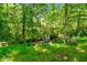 Cozy firepit area with Adirondack chairs nestled among lush greenery, perfect for outdoor entertaining at 1661 Reno Sharps Store Rd, Bear Creek, NC 27207