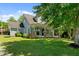 Traditional home boasts a covered porch, brick accents, and a well-manicured lawn at 1661 Reno Sharps Store Rd, Bear Creek, NC 27207