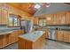 A bright kitchen featuring stainless steel appliances, wood cabinets, a kitchen island, and tile flooring at 1661 Reno Sharps Store Rd, Bear Creek, NC 27207