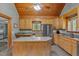 A functional kitchen featuring stainless steel appliances, wood cabinets, an island, and natural light at 1661 Reno Sharps Store Rd, Bear Creek, NC 27207