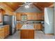 Spacious kitchen featuring stainless steel appliances, an island, and a beautiful wood-paneled ceiling at 1661 Reno Sharps Store Rd, Bear Creek, NC 27207