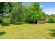 Expansive green lawn showcases the outbuildings of this property with mature trees adding to its appeal at 1661 Reno Sharps Store Rd, Bear Creek, NC 27207
